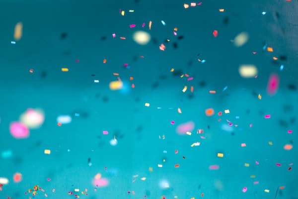 There's a flying confetti all around in the air on a bluish background